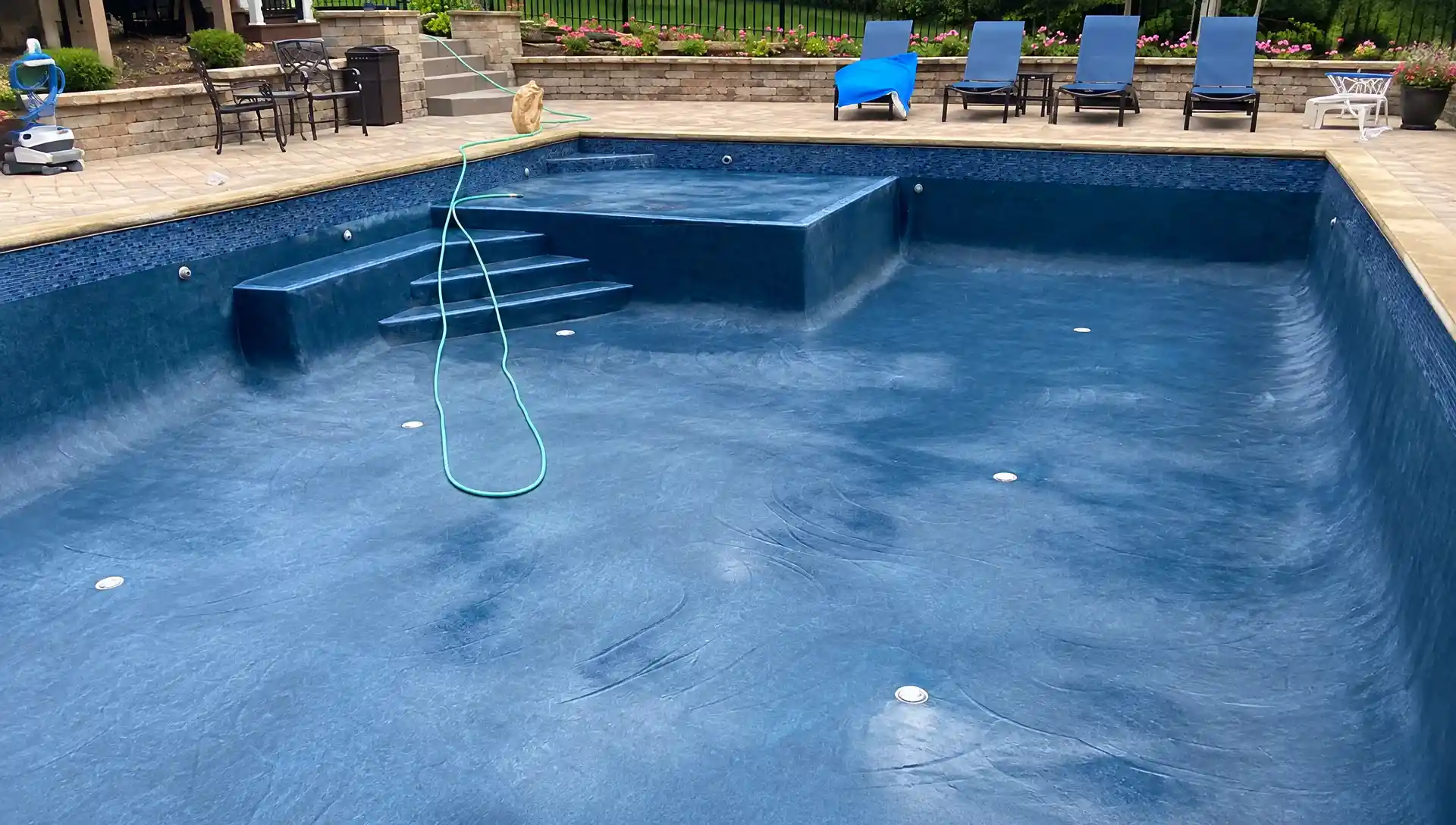 A drained in-ground pool before M & G Pools worked on it